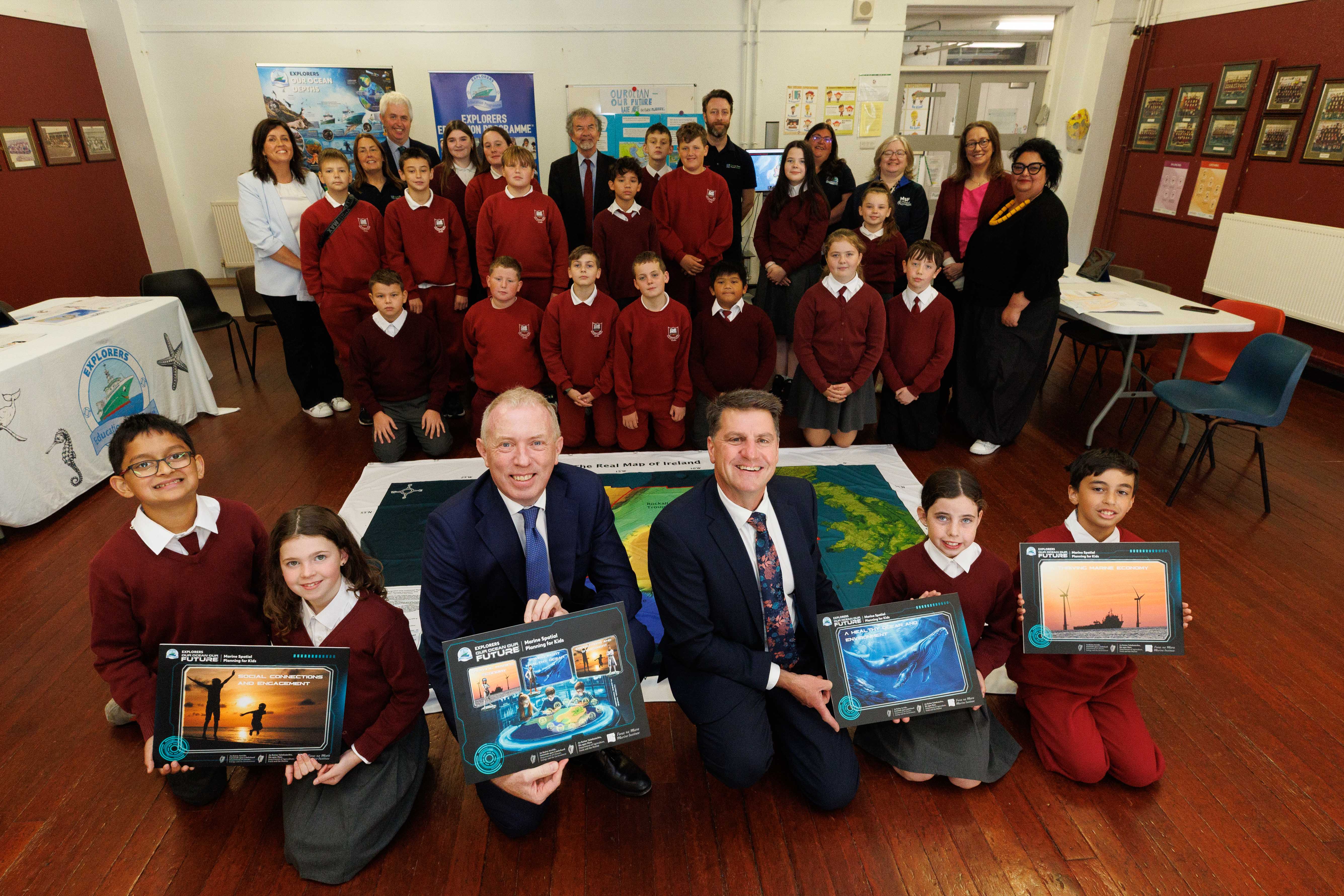 Minister Timmy Dooley, DCEE and Rick Officer, CEO, Marine Institute with school children and Explorers course materials
