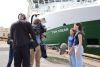 Two female school students interviewed on camera on the background of RV Tom Crean